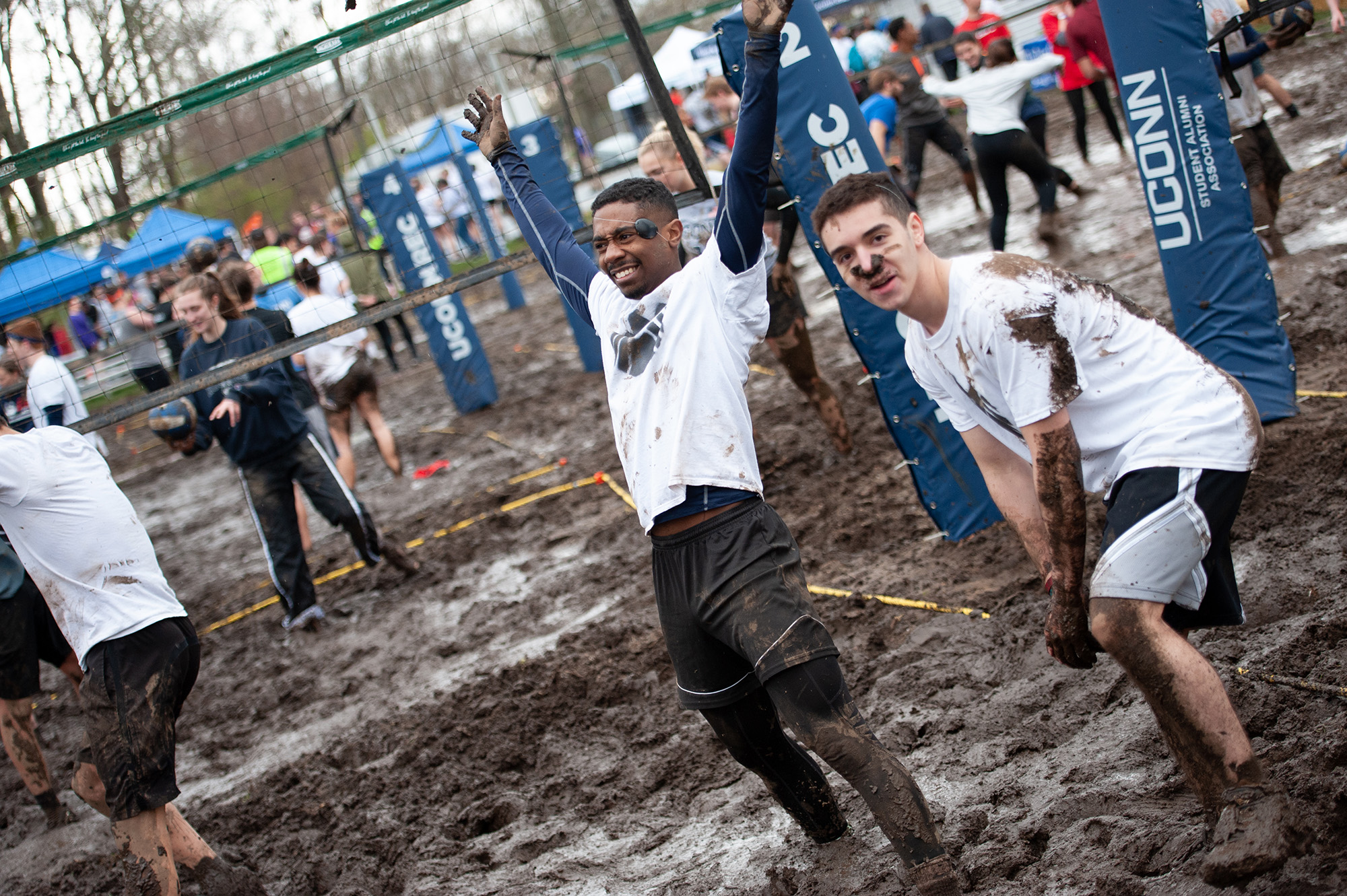 Two men ready their serve during oozeball tournament